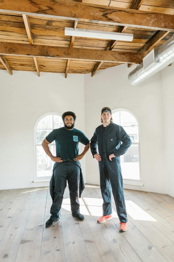 Two professional movers in an empty apartment, ready to assist with moving services.